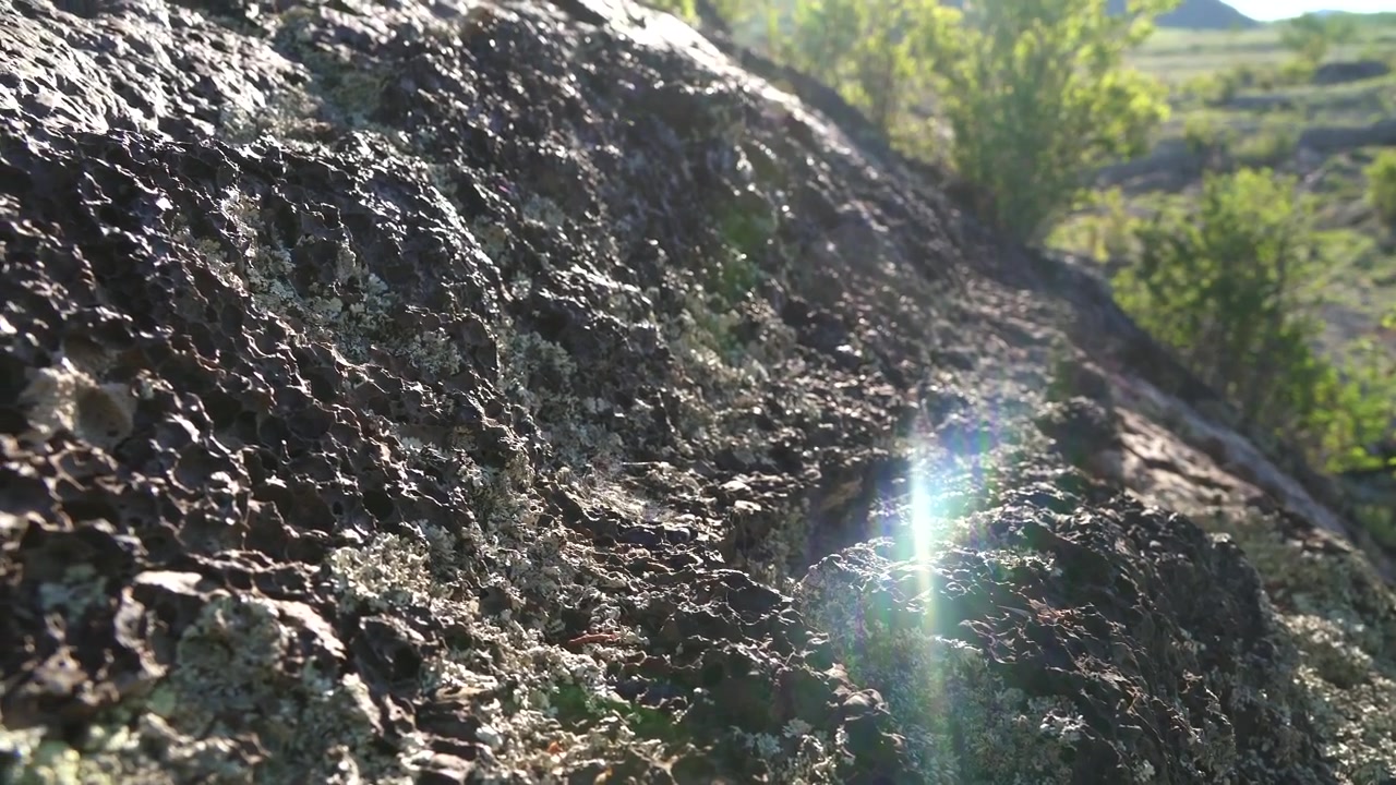 Primo piano di roccia vulcanica texturizzata con bagliore solare