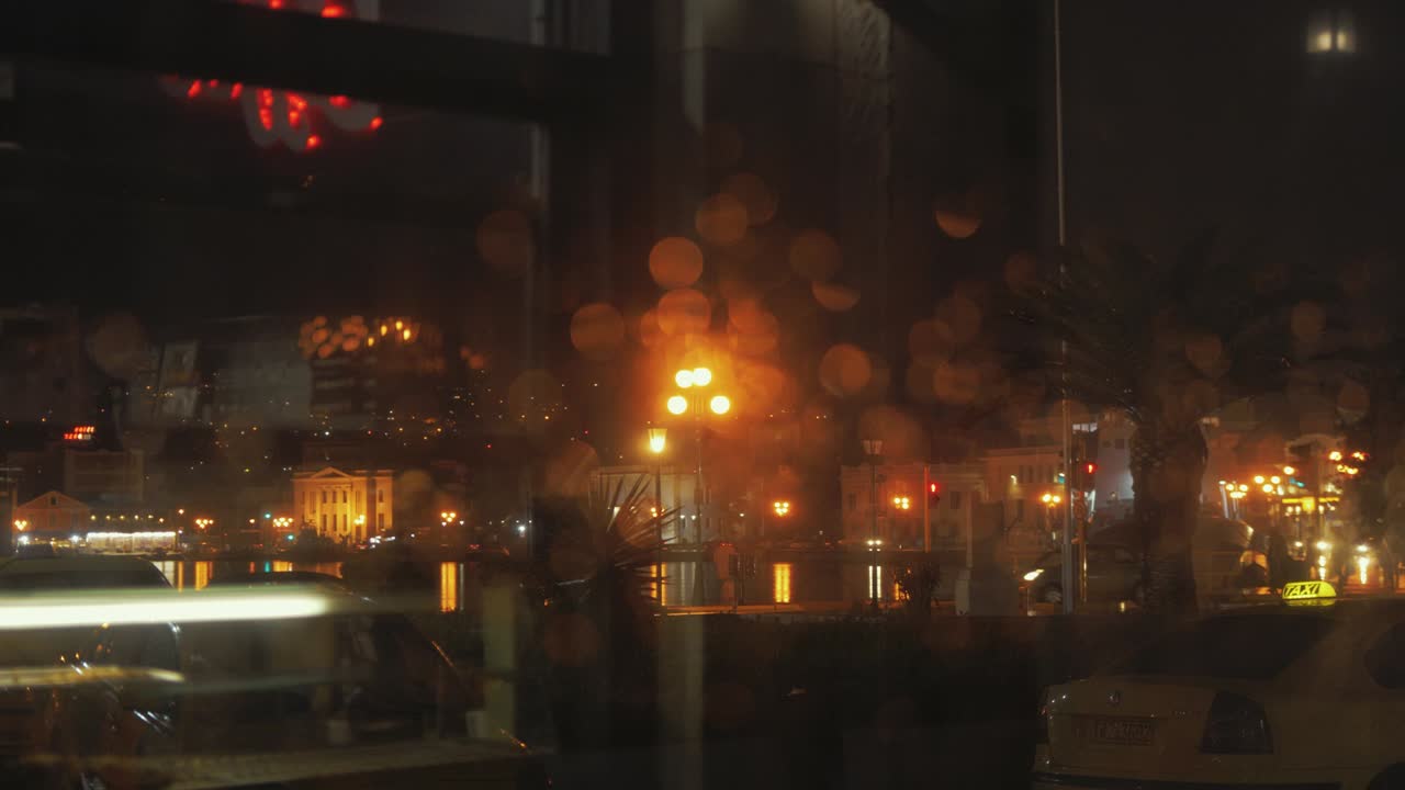 밤에 비 오는 창문을 통해 초점을 맞추는 보케 도시의 불빛