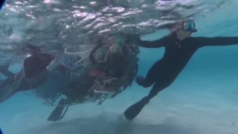 divers work to remove tangled fishing nets from coral reefs near hawaii 1