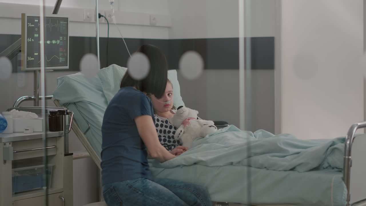 Hospitalized sick child resting in bed wearing nasal tube recovering after medical surgery