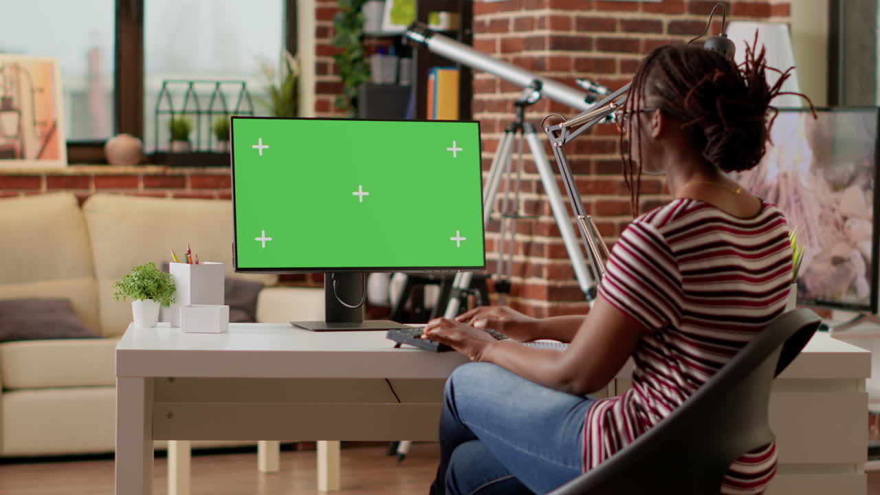 Donna che lavora su un computer con schermo verde