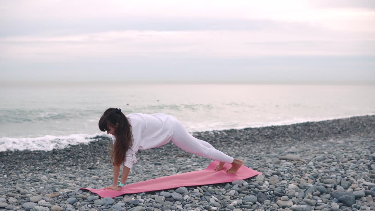 mujer practicando yoga en la playa