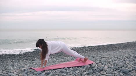 woman practicing yoga on a beach