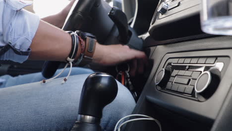 view of male hand inserting key in ignition and starting up car in slow motion