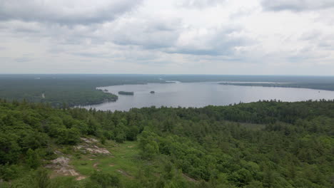 Aerial shot of tree covered mountain into lake, summertime. Calabogie ski hill. Ontario Canada