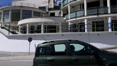 a car drives past a modern building