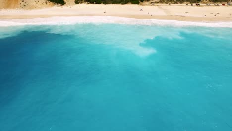 Turquoise-waves-crashing-on-Myrtos-beach-in-Kefalonia,-Greece,-aerial-view