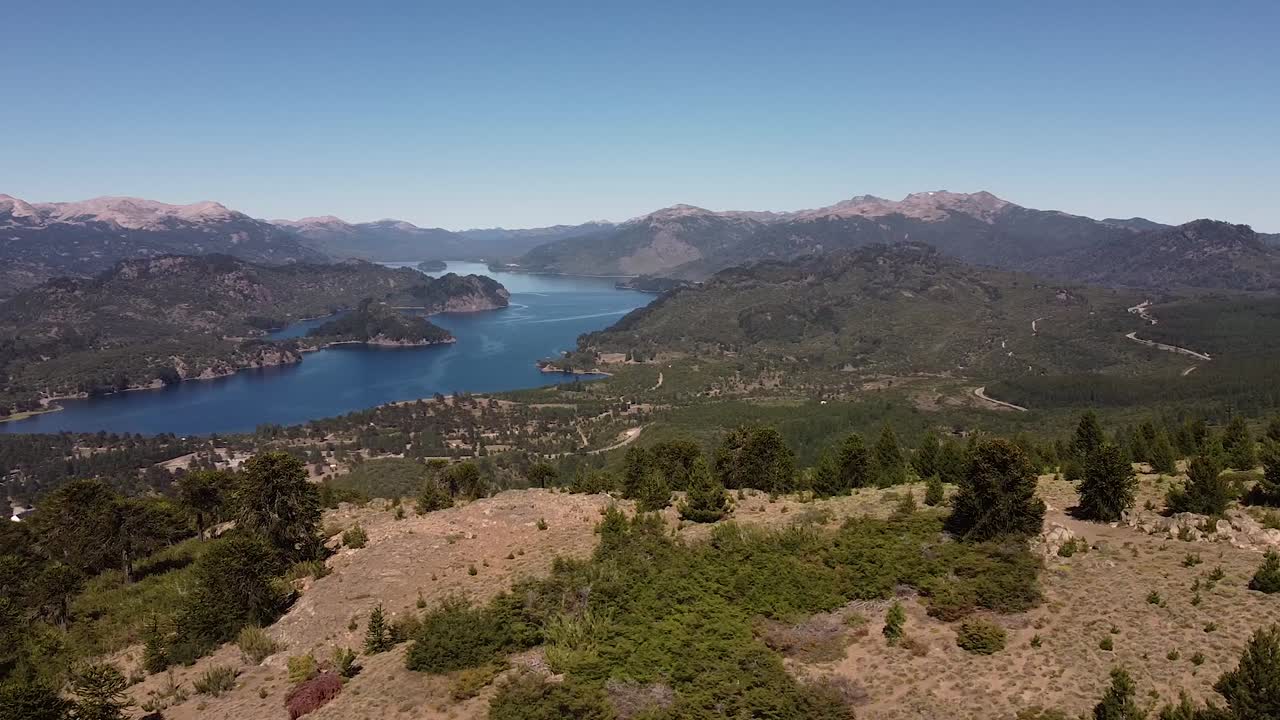 vista aérea sobre el lago en las montañas a lo lejos, naturaleza intacta durante el día soleado y clima despejado, capturada en patagonia, argentina, sudamérica