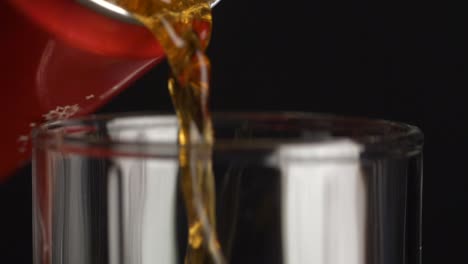 pouring soda from can into glass