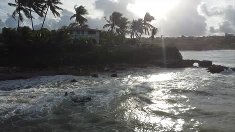 Palmeras-Junto-Al-Mar,-Puesta-De-Sol,-Casa-Junto-Al-Acantilado-Y-Océano-Tranquilo