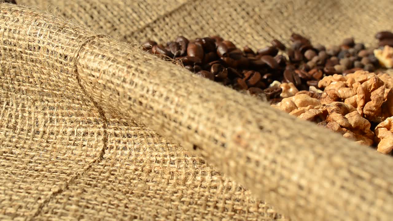 Café, noz e pimenta sobre um saco de estopa. Café contra um saco