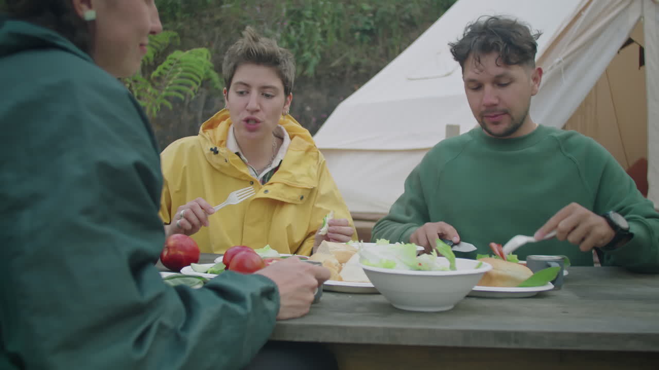 Tourists Eating Dinner and Speaking Outside of Glamping Tent