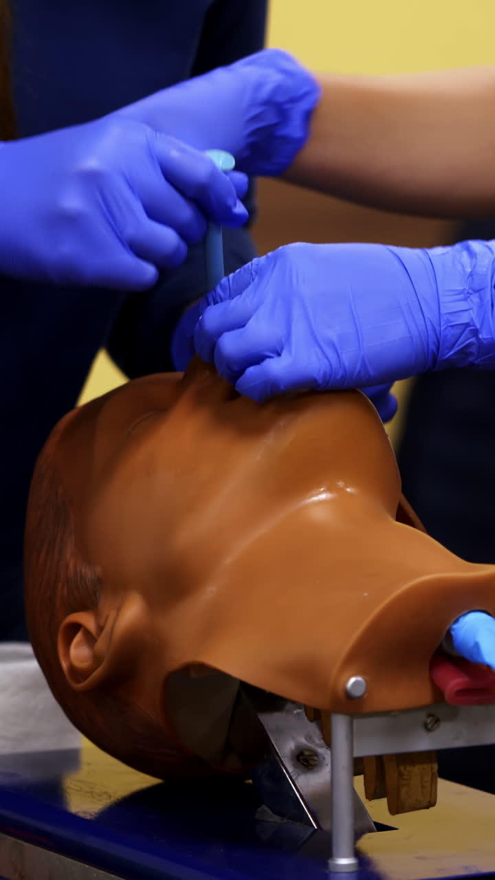 Medical course on mannequin head. Specialist teaches student medical exercise for treating patient in the training center. Vertical video