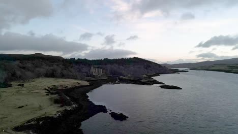 dunvegan castle on the isle of skye, surrounded by woodlands and water at dusk, aerial view