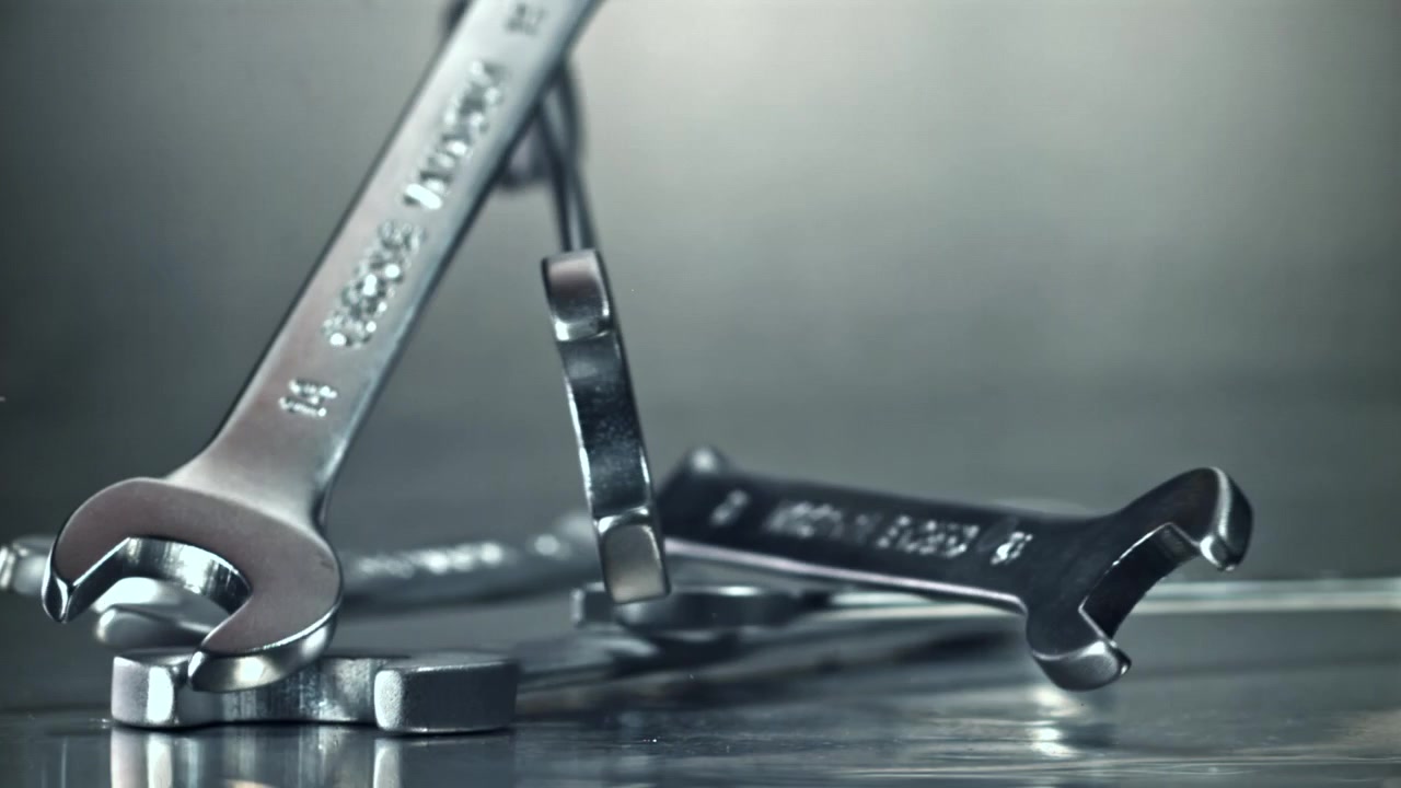 Metal Wrenches Falling in Slow Motion onto a Reflective Surface