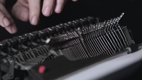 close-up of a person's hand typing on a vintage typewriter