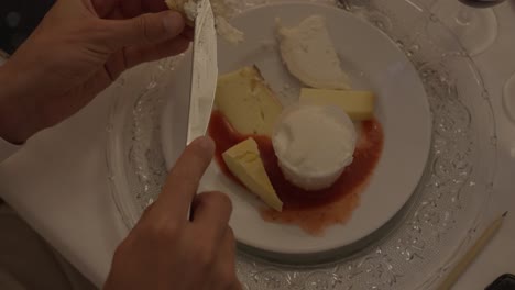 cámara lenta de primer plano de un invitado poniendo queso de un pedazo de pan