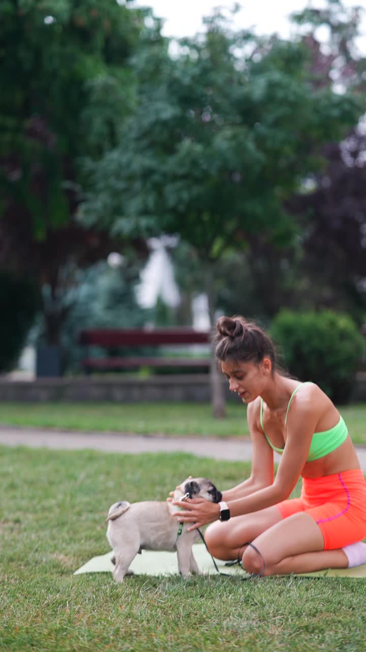 여자 는 개 와 함께 야외 에서 요가 를 연습 하고 있다