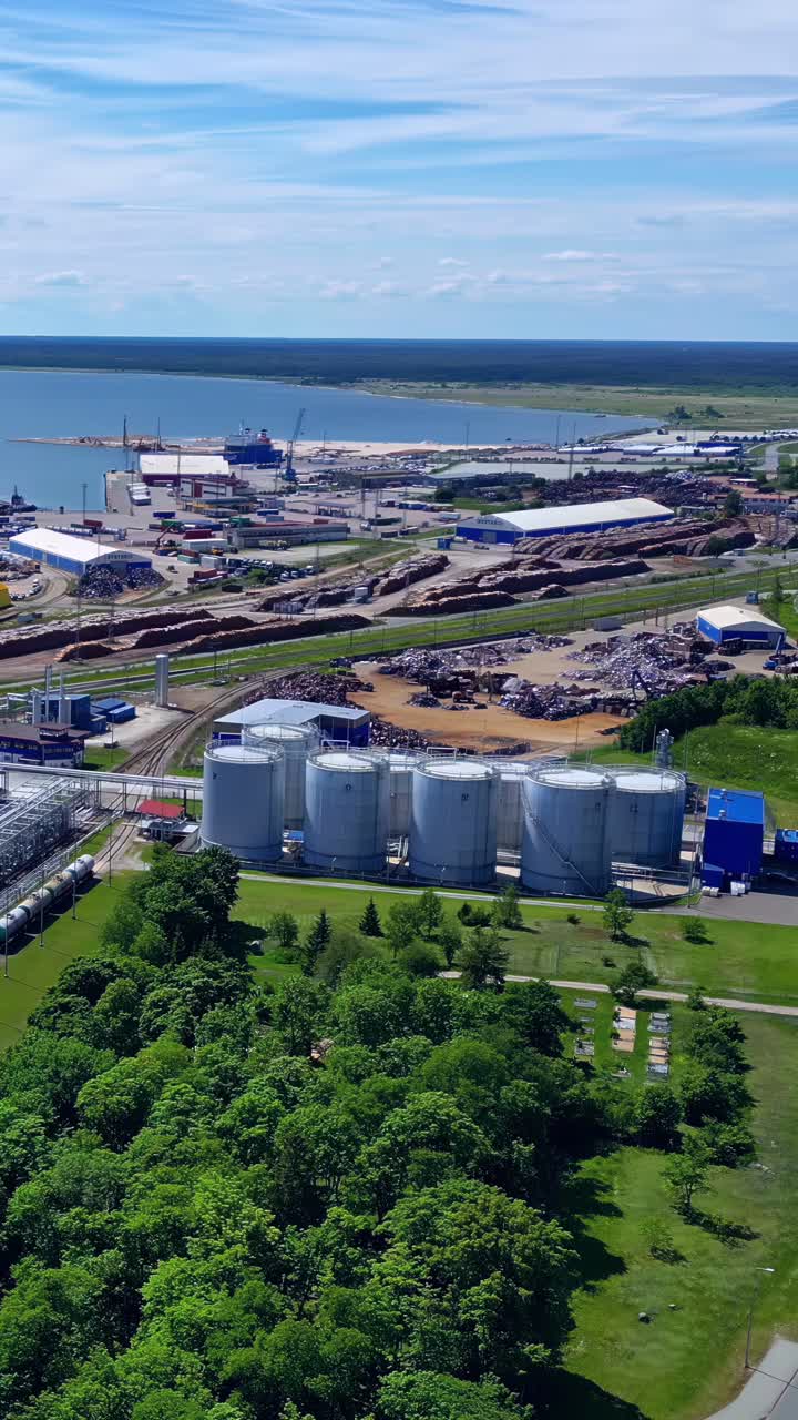 Aerial panorama of Vitol Terminal Latvia’s oil storage tanks and industrial facilities at the Port of Ventspils on the Baltic Sea coast - vertical parallax