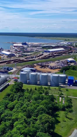 aerial panorama of vitol terminal latvia’s oil storage tanks and industrial facilities at the port of ventspils on the baltic sea coast - vertical parallax