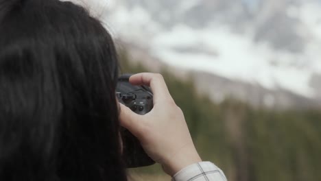 cropped view of a woman with camera taking photos of dolomite mountain ridge in italy