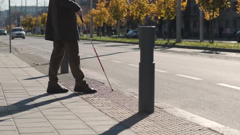 blinded man waiting for bus at a bus station