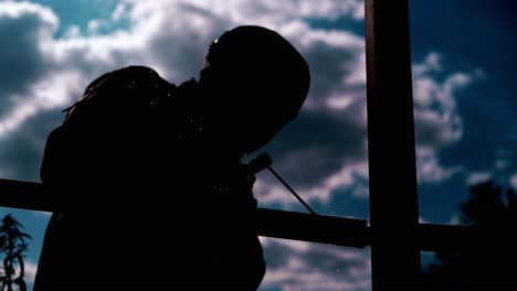 Bauarbeiter-Dunkle-Silhouette-Mit-Schweißgerät-Gegen-Wolken