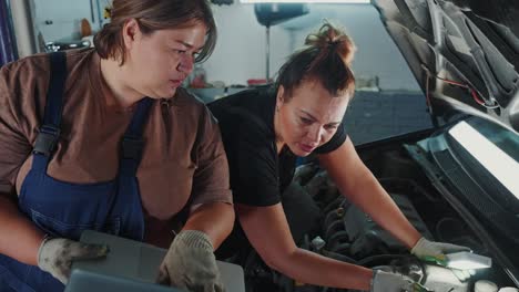 women car mechanics inspecting a car engine