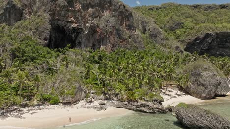 aerial flyback from playa fronton beach with people in summer season, samana in dominican republic