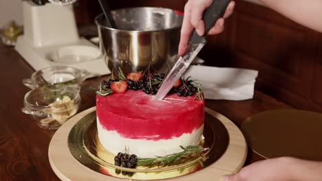 cutting a beautiful decorated cake with fresh berries