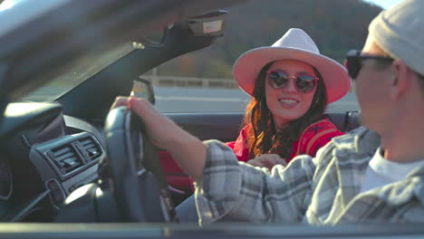 couple enjoying a scenic drive in a convertible