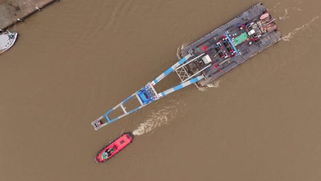 birdseye, tug boat orchestrating the graceful movement of crane platform