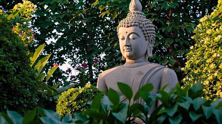 A serene Buddha statue surrounded by lush greenery, captured at eye level