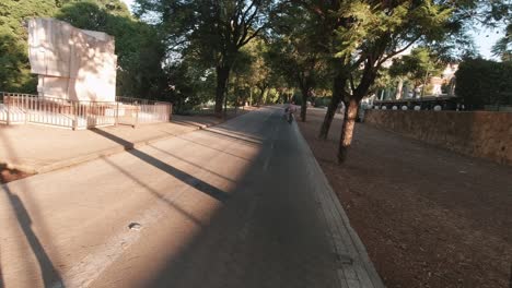 pov sevilla electric scooter mobility early morning commute ride in park with bikes and runners