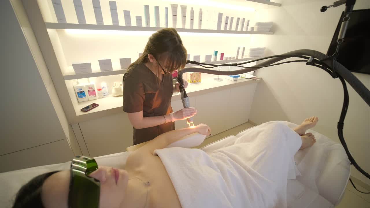 Aesthetician Performing Laser Hair Removal on Woman's Arm