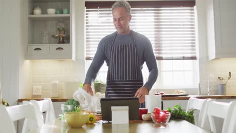 Portrait-of-happy-caucasian-man-wearing-apron,-standing-in-kitchen,-cooking-dinner