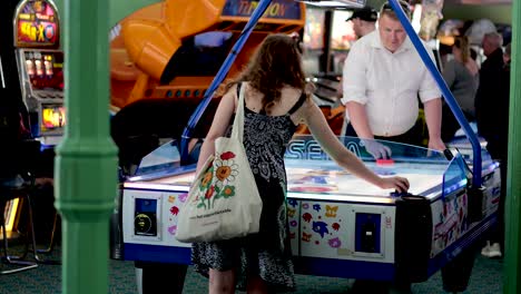 two people playing air hockey in arcade