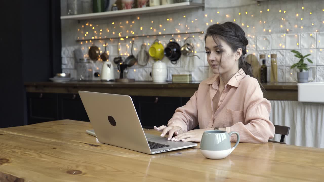 mujer trabajando en una computadora portátil en la cocina