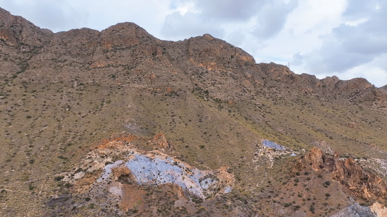 Aerial flies close up to vibrant eroded blue grey soils of Sierra del Aguilon