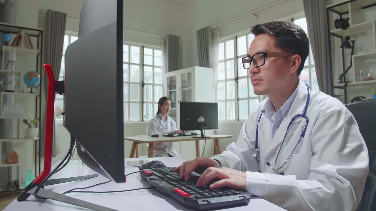 Young Asian Man Doctor Is Using Desktop Computer In Workplace. Medical Concept