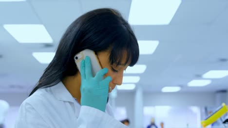 Female-scientist-talking-on-mobile-phone-4k