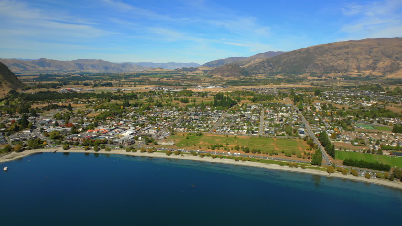 Wānaka resort town in the South Island of New Zealand with a beach on the Lake Wanaka - aerial parallax
