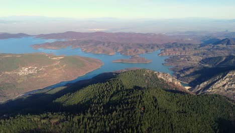 Bird's-eye-view-above-Lake-Kerkinis-Greece-at-midday-with-deep-valley-shadows