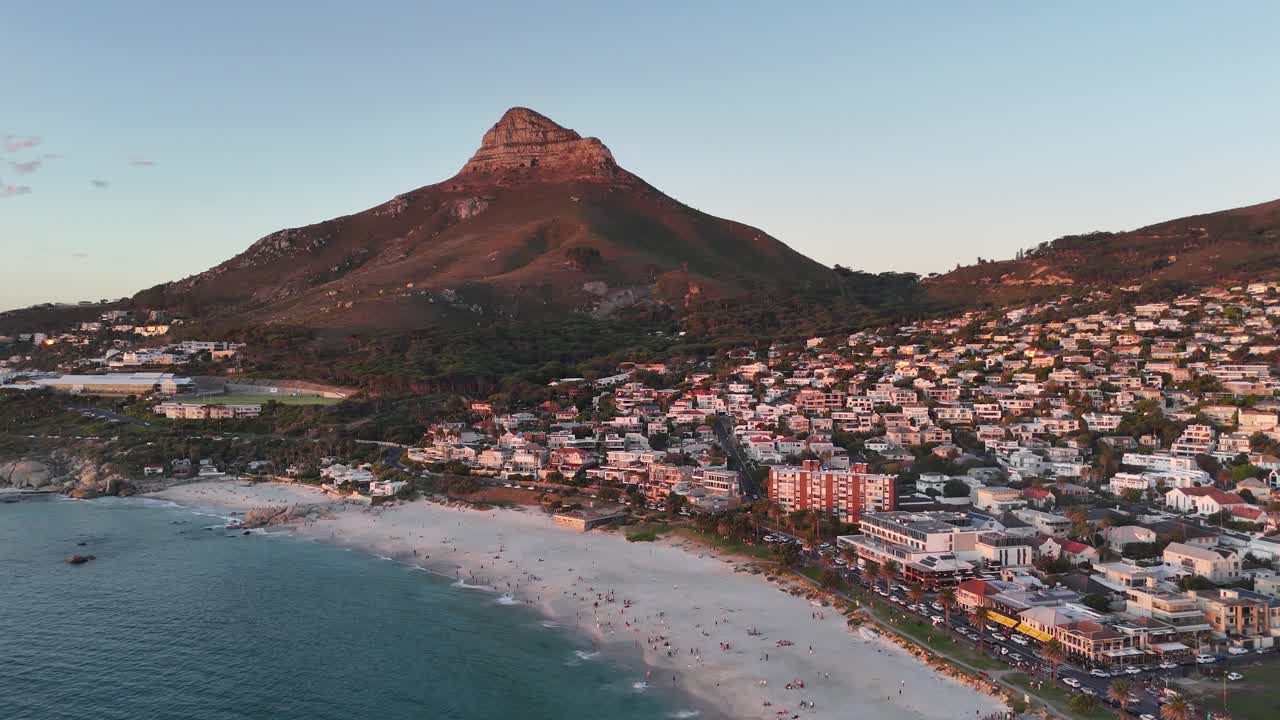 Aerial sunset view of Lion's Head mountain in Camps Bay, Cape Town, South Africa drone fly above popular beach high angle view cinematic