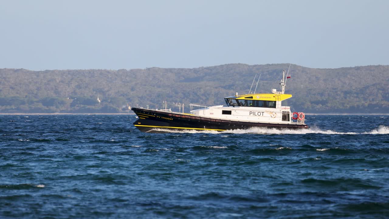 A pilot boat speeds through the ocean near Bellarine, Victoria, under clear skies, showcasing maritime navigation