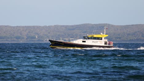 a pilot boat speeds through the ocean near bellarine, victoria, under clear skies, showcasing maritime navigation