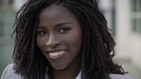 smiling african american woman with dreadlocks looking at camera