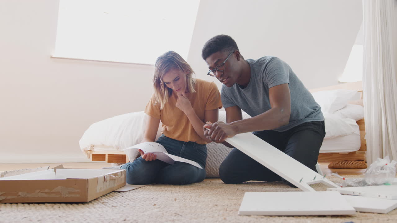 Couple In New Home Putting Together Self Assembly Furniture