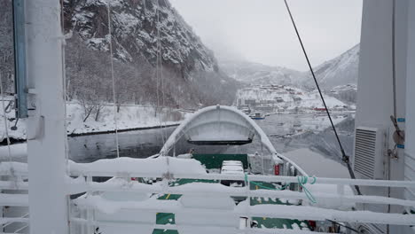 pov footage of a ferry boat ride through geirangerfjord, norway, highlighting the fjord's tranquil beauty and the surrounding snowy mountains in winter