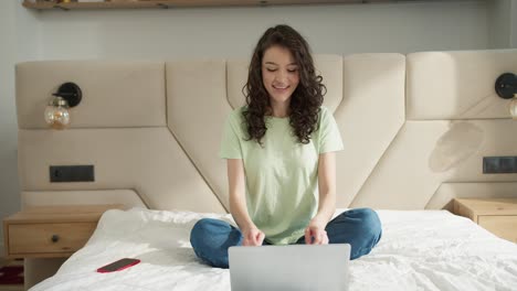 Woman-communicates-with-parents,-showing-her-background,-sitting-on-bed-at-home